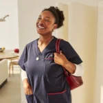 Portrait of a smiling woman caregiver in navy scrubs