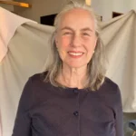 Portrait of a silver-haired woman caregiver in a navy cardigan